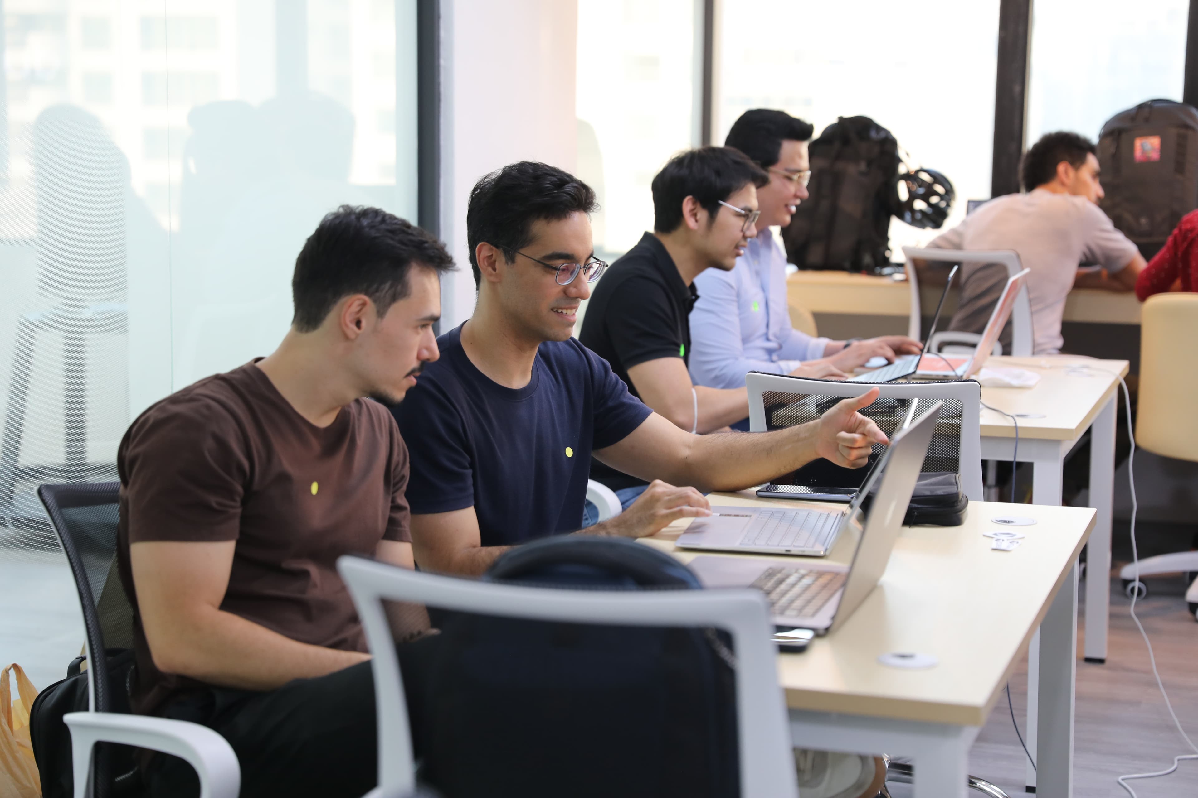 Row of attendees at laptops, window lighting
